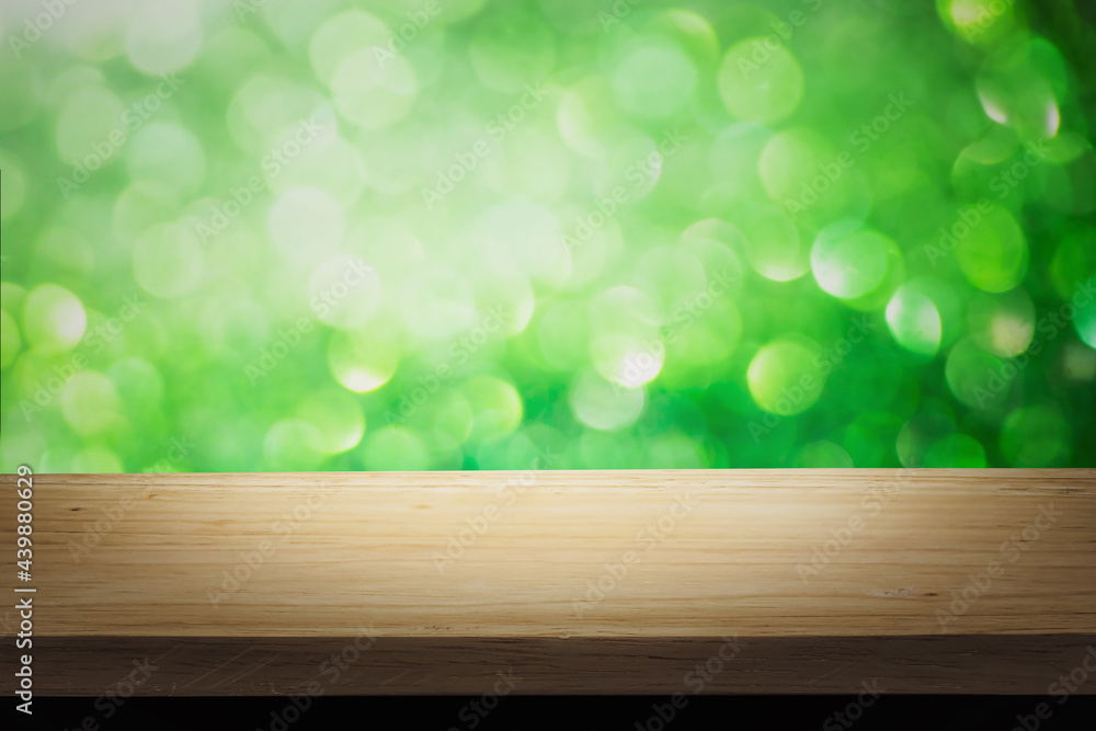 Poster green bright lights bokeh background of wooden table in nature of abstract blurred and space use for