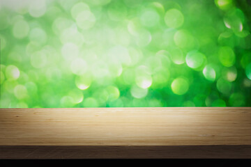 Green bright lights bokeh background of wooden table in nature of abstract blurred and space use for product