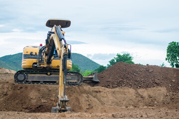 mini excavator digging soil with mountain background