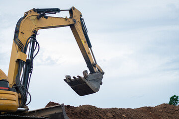 A mini excavator is digging the soil in the field.