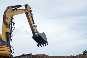 A mini excavator is digging the soil in the field.