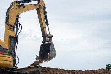 A mini excavator is digging the soil in the field.