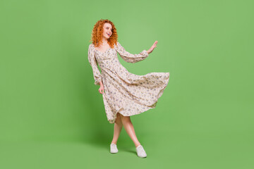 Full body photo of dreamy happy nice young woman look empty space fly skirt isolated on green color...