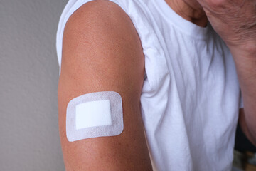 old european man, senior 60 years after injection, patient in shirt, white plaster on hand, medical...