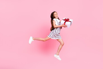 Full length body size photo schoolgirl jumping high careless giving present at party isolated pastel pink color background