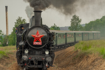 Steam train near Sazava river in south of Prague in summer cloudy day