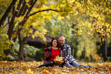 Naklejka na ściany i meble middle-aged couple on autumn walk outdoors. family of respectable age in autumn park. Love and tender touch. Romantic date in autumn park. Happy family is together during all their life. for life