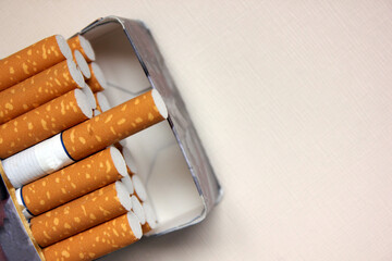A pack of cigarettes on a white background. open pack of cigarettes. Yellow filter. Harm to health. It is a bad habit. The concept of World No Tobacco, Tobacco and Lung Health. Cigarettes in a tutu.