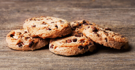 heap of cookies with chocolate on wooden background