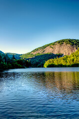 Fototapeta na wymiar A beautiful mountain lake with a rock monolith mountain in the background.
