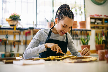Craftswoman working with antique carved object 