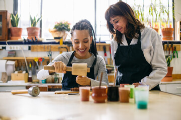 Craftswomen restoring woodwork in workshop 