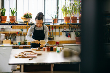 Positive female artisan restoring wooden piece 