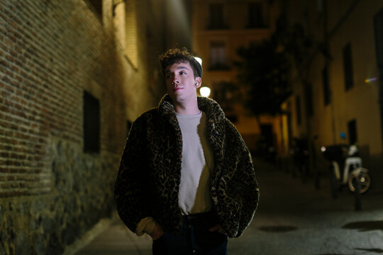 Young gen-z non-binary person in the street at  night