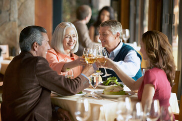 Two mature couples having dinner at restaurant