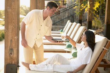 Woman at luxury resort being served drink