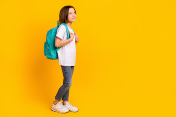Fototapeta na wymiar Full length body size photo schoolgirl smiling wearing blue bag looking blank space isolated bright yellow color background