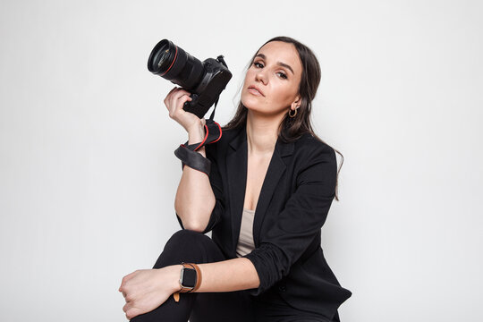 Woman photographer holding a camera in studio