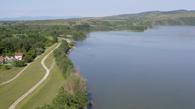 Drone aerial shot of big river Danube and its river bank. Drone is moving from left to rigth