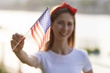 Patriotic holiday. Happy family, mother and daughter with American flag outdoors on sunset. USA celebrate independence day 4th of July.