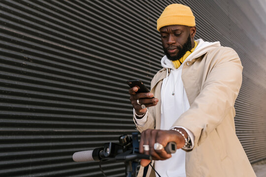 Man using a mobile standing on an electronic scooter.
