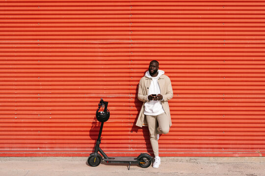 Man using cell phone and electric scooter