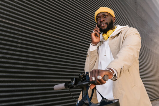 Man using a mobile standing on an electronic scooter.