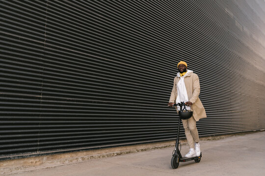 Black man driving an electric scooter