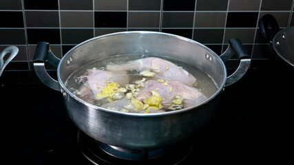 Boiling the raw chicken in hot water to soften the meat in the kitchen. Food preparation for lunch.
