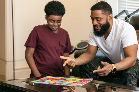 Father And Son With Completed Puzzle