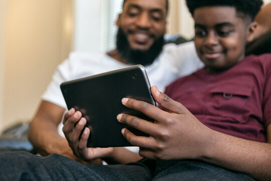 Father And Son Use Digital Tablet At Home