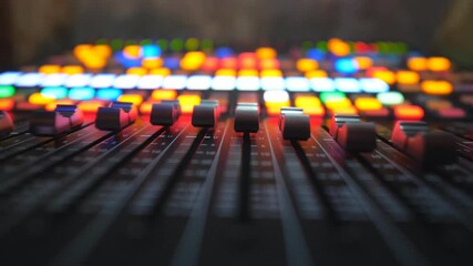 Low view of moving buttons on dj remote or soundboard. Working process in recording studio. Blurred background with brightly glow keys. Musical player at night party. Slow motion Close up