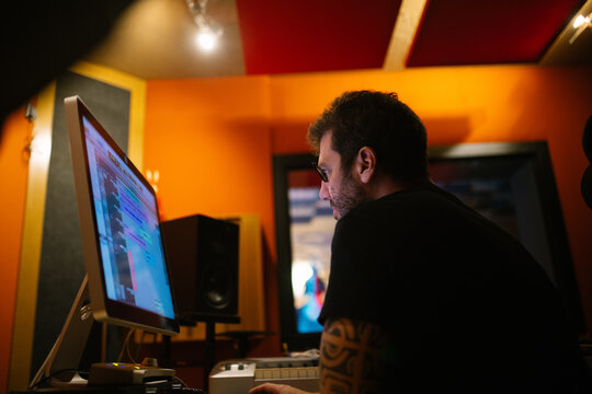 Sound engineer against computer in recording studio