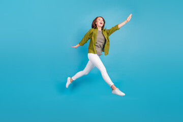 Fototapeta na wymiar Full length photo of happy young woman jump up air good mood walk isolated on blue color background