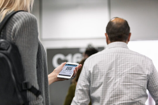 Travel: Woman Checks Flight Info While Waiting In Line At Gate