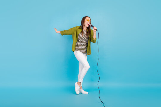 Full body photo of attractive crazy young woman sing mic karaoke star isolated on pastel blue color background
