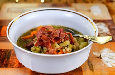 Vegetable soup on a plate on the wooden table