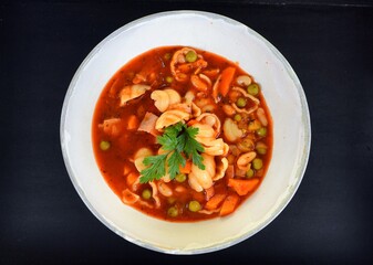 Vegetable soup on a plate on the wooden table