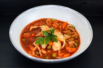 Vegetable soup on a plate on the wooden table