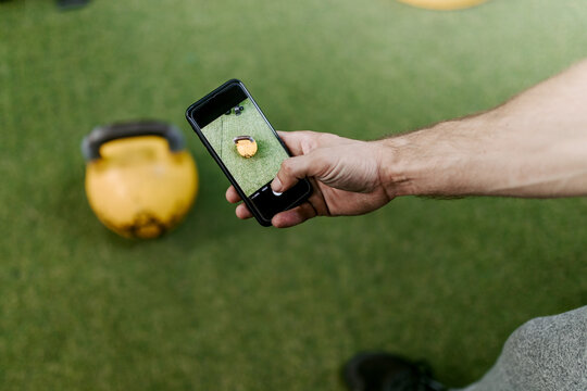 Person taking photo with mobile phone of weight ay the gym