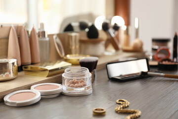 Many different cosmetic products on dressing table indoors