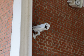 surveillance camera mounted on a red stone wall