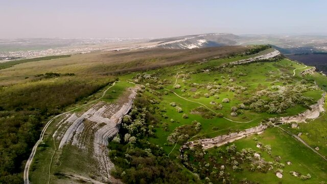 Aerial photography of the Crimean Mountains. An ancient city in a rock. Mountains, peaks, rocks, rocks, ridges, landscape, green grass, sky, clouds, nature, raw nature, drone video