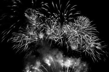 Sparkling white fireworks display in a black sky. Black and white photograph.