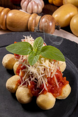 Gnocchi with natural organic tomato sauce without pesticides with grated Parmesan cheese and basil leaves.