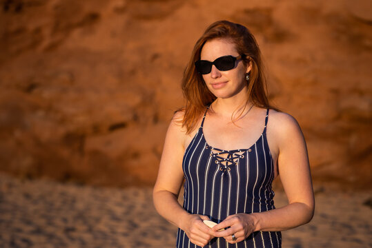 Portrait of Redhead Woman Holding Seashell on PEI Beach at Sunset