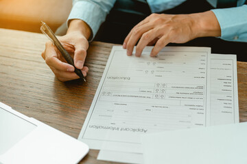 Close up man hands is filling out a job application form. Unemployed concept.