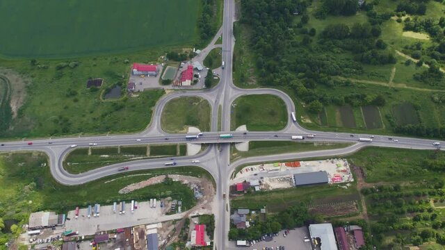 Aerial drone view of highway multi-level junction road with moving cars near to city haos. camera moves back and tilt up The concept of the urban city. Ukraine Vynnyky