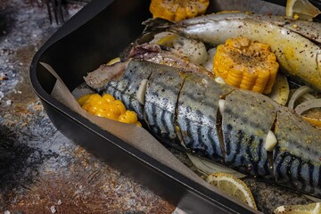 Close-up marinated mackerel with vegetables. Saltwater fish with spices and vegetables in a cast iron baking dish on a rustic background Healthy and tasty seafood. Mediterranean diet. Food photography