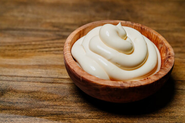 white sauce. small wooden bowl with mayonnaise on the kitchen table. 